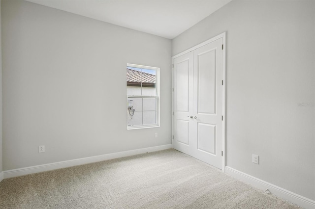 carpeted empty room featuring baseboards