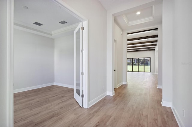 corridor with light hardwood / wood-style floors and ornamental molding