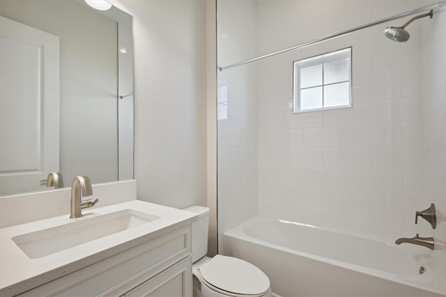 full bathroom with vanity, tiled shower / bath combo, and toilet