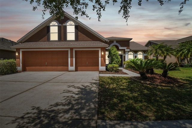 view of front of property with a garage and a yard