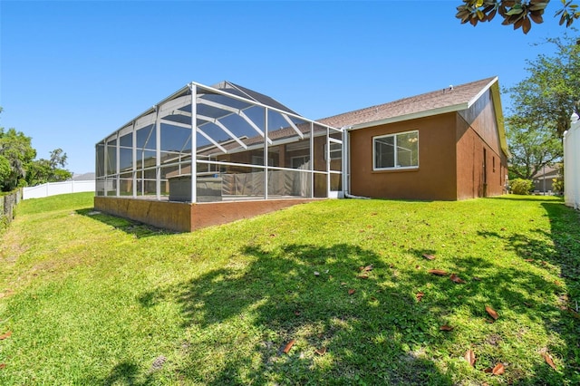 rear view of property with a yard and a lanai