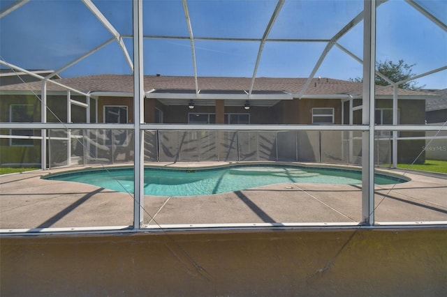 view of pool featuring a patio area, ceiling fan, and glass enclosure