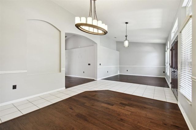 spare room featuring vaulted ceiling, light hardwood / wood-style flooring, and plenty of natural light