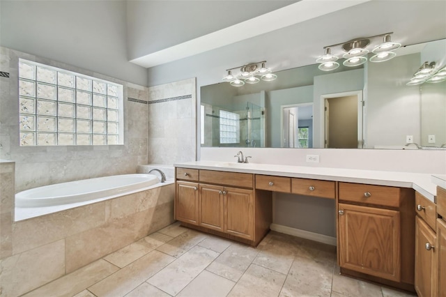 bathroom featuring oversized vanity, tiled tub, and tile flooring