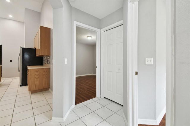 kitchen with tasteful backsplash, stainless steel fridge, and light tile floors