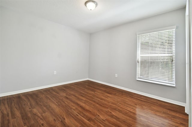 unfurnished room with dark hardwood / wood-style floors