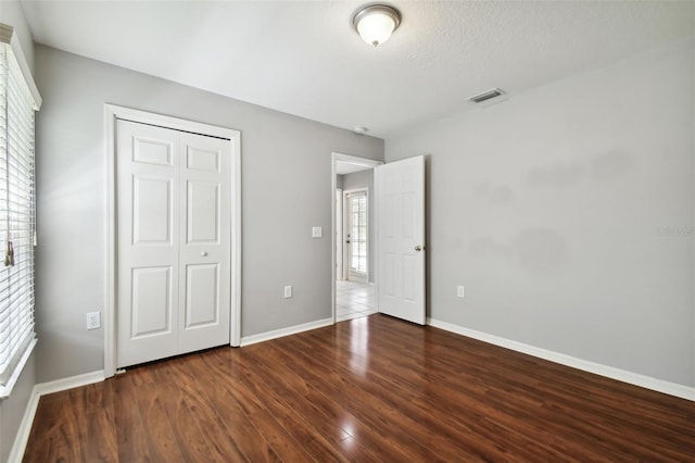 unfurnished bedroom featuring dark tile flooring, a closet, and a textured ceiling