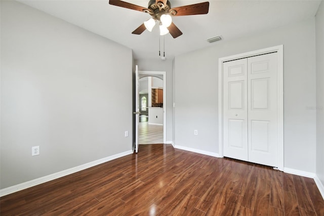 unfurnished bedroom with a closet, ceiling fan, and dark hardwood / wood-style floors