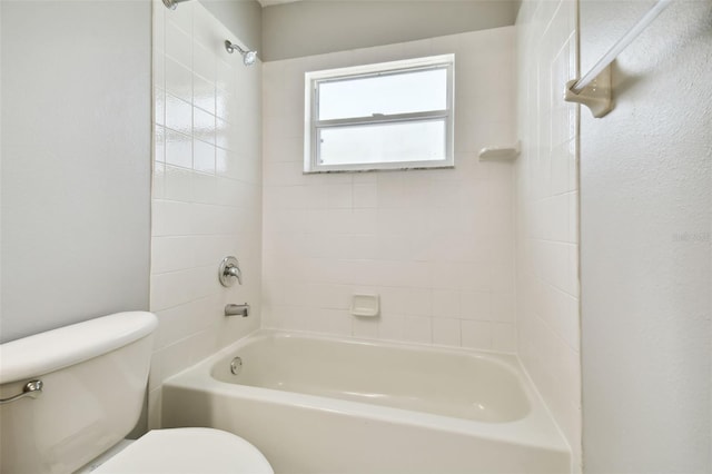 bathroom featuring tiled shower / bath and toilet