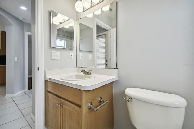 bathroom with tile floors, toilet, and large vanity