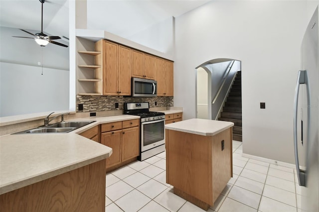 kitchen featuring high vaulted ceiling, backsplash, stainless steel appliances, light tile floors, and ceiling fan