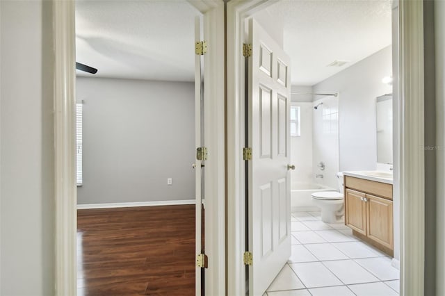 interior space featuring shower / bath combination, toilet, tile flooring, a textured ceiling, and vanity