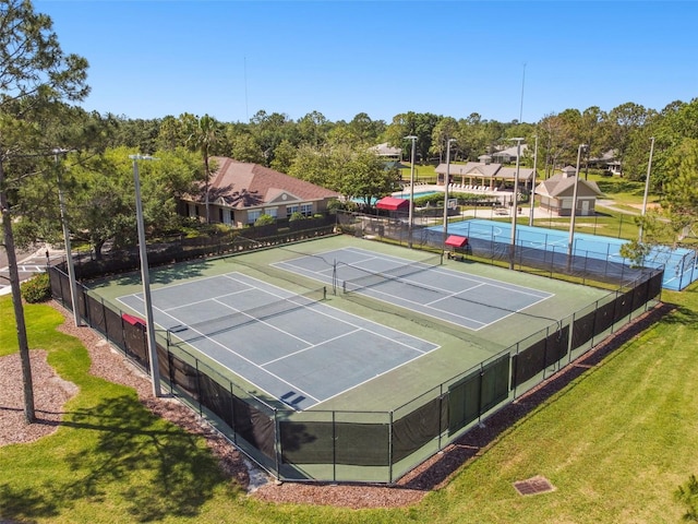 view of tennis court with a yard