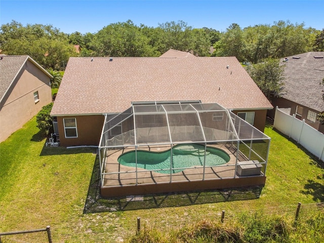 exterior space with a lawn, a lanai, and a fenced in pool