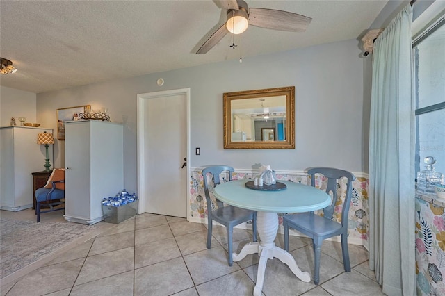 dining room featuring ceiling fan, light tile floors, and a textured ceiling