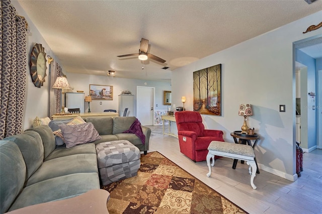 living room featuring a textured ceiling, ceiling fan, and hardwood / wood-style flooring