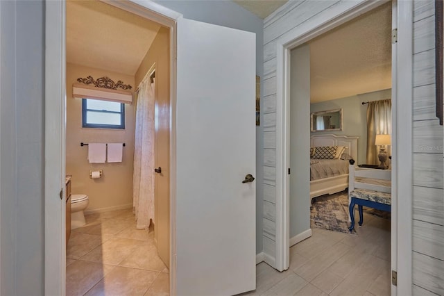 bathroom featuring a textured ceiling, tile floors, and toilet