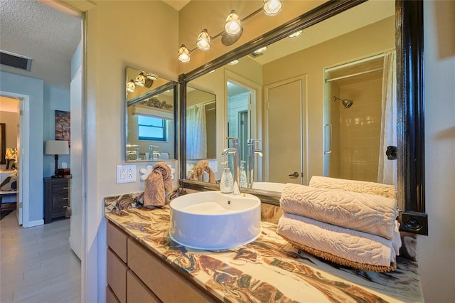 bathroom with tile flooring, a textured ceiling, and large vanity