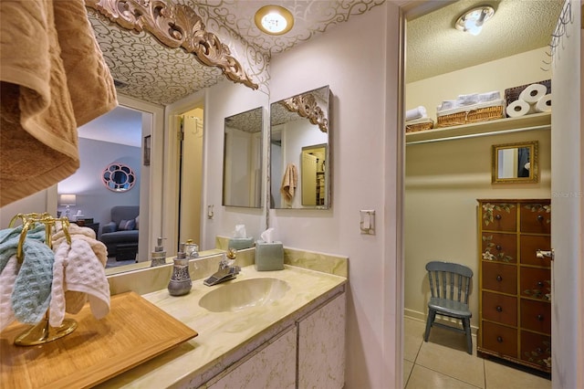 bathroom featuring a textured ceiling, tile floors, and vanity with extensive cabinet space