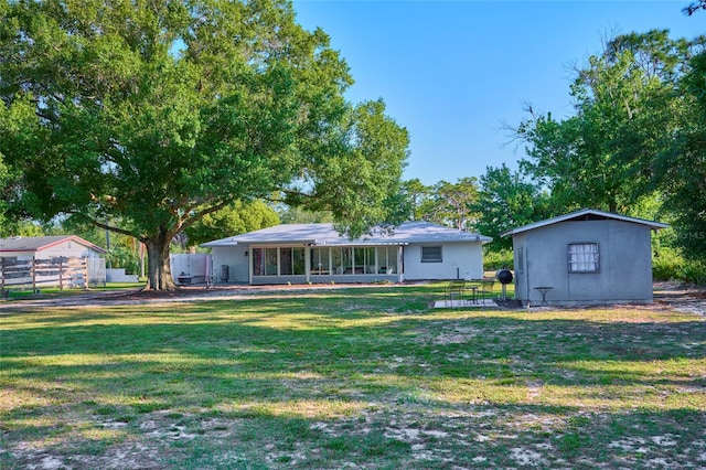 back of property with an outdoor structure and a lawn