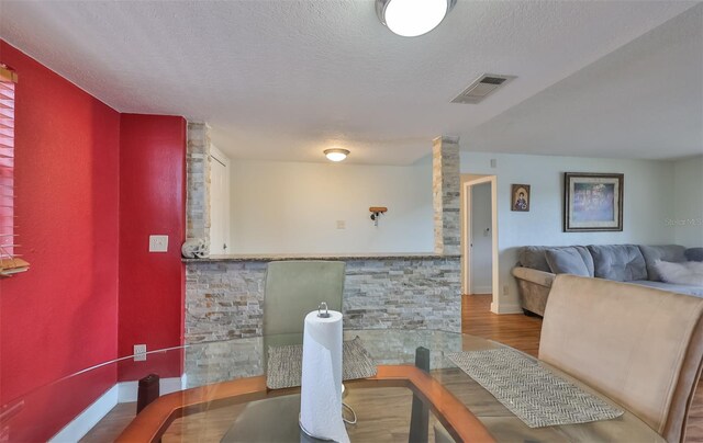 dining area featuring hardwood / wood-style floors and a textured ceiling