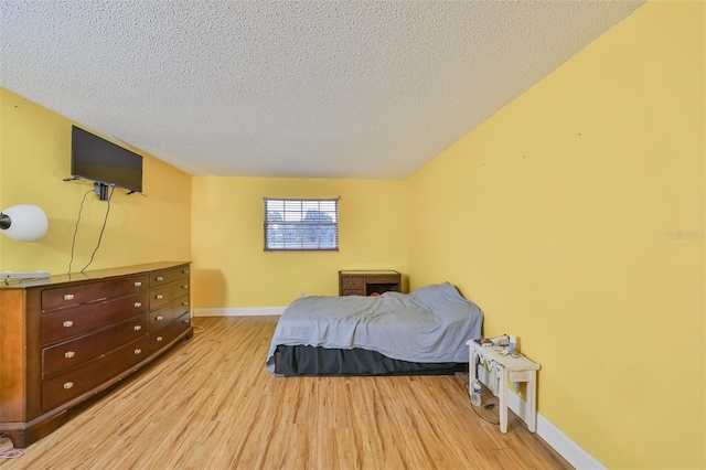 bedroom with light hardwood / wood-style flooring and a textured ceiling