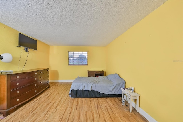 bedroom with light hardwood / wood-style floors and a textured ceiling