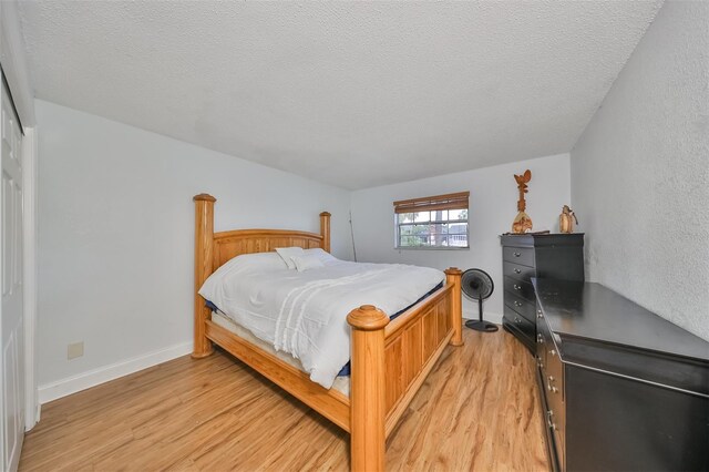 bedroom featuring a textured ceiling and light wood-type flooring