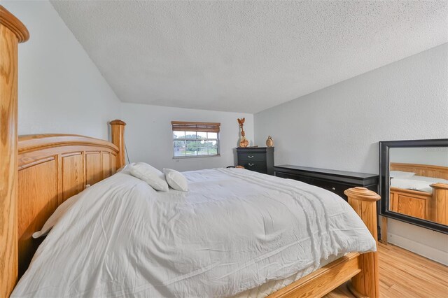 bedroom with light hardwood / wood-style flooring and a textured ceiling