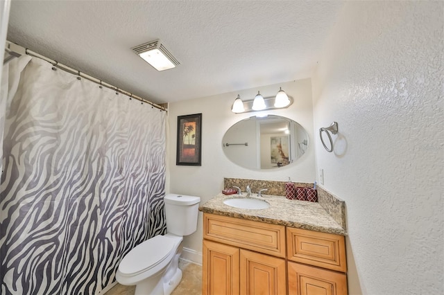 bathroom with a textured ceiling, tile flooring, vanity, and toilet