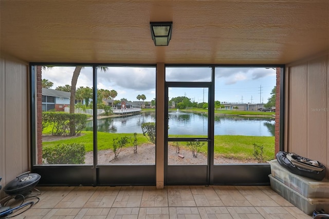 unfurnished sunroom featuring a water view