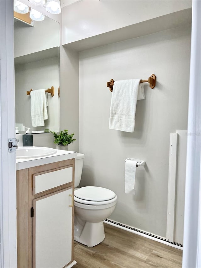 bathroom featuring vanity, hardwood / wood-style flooring, and toilet