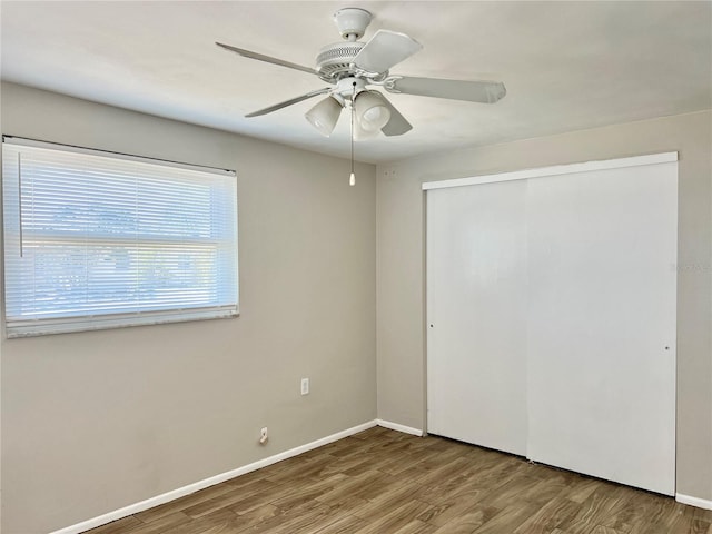 unfurnished bedroom with a closet, ceiling fan, and hardwood / wood-style flooring