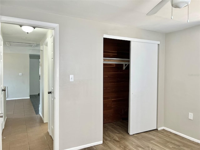 unfurnished bedroom with light hardwood / wood-style flooring, a closet, and ceiling fan