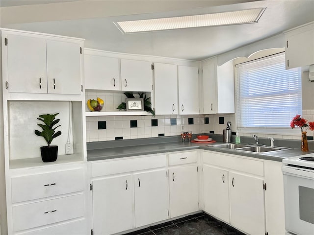 kitchen featuring electric range, sink, white cabinetry, and tasteful backsplash