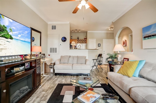 living room featuring hardwood / wood-style flooring, crown molding, and ceiling fan