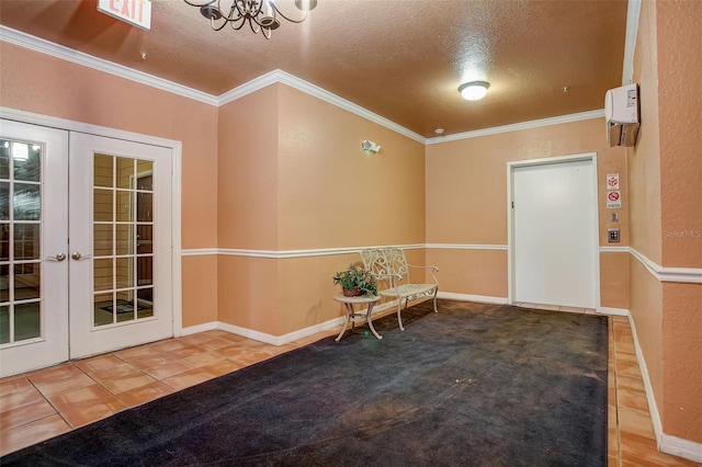 unfurnished room featuring a textured ceiling, french doors, a notable chandelier, and ornamental molding