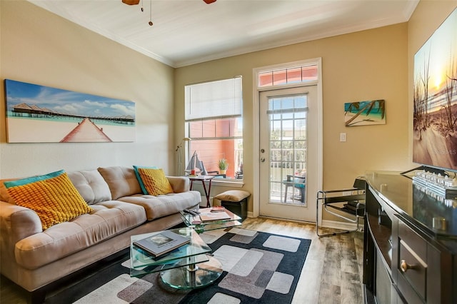 living room with light wood-type flooring, baseboards, ceiling fan, and crown molding