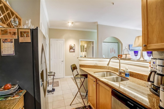 kitchen featuring light tile patterned floors, stone countertops, a sink, ornamental molding, and stainless steel appliances