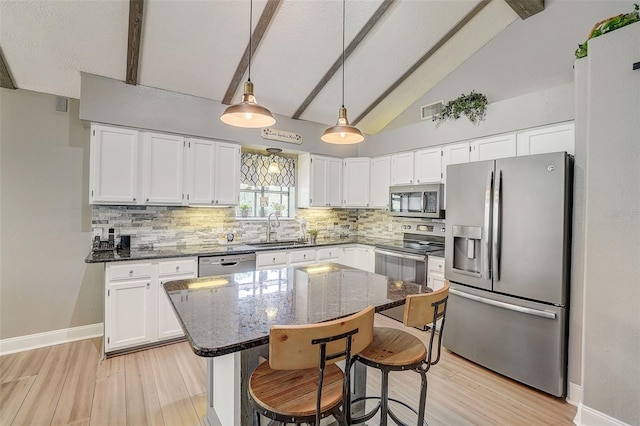 kitchen featuring light hardwood / wood-style floors, stainless steel appliances, vaulted ceiling with beams, white cabinetry, and sink