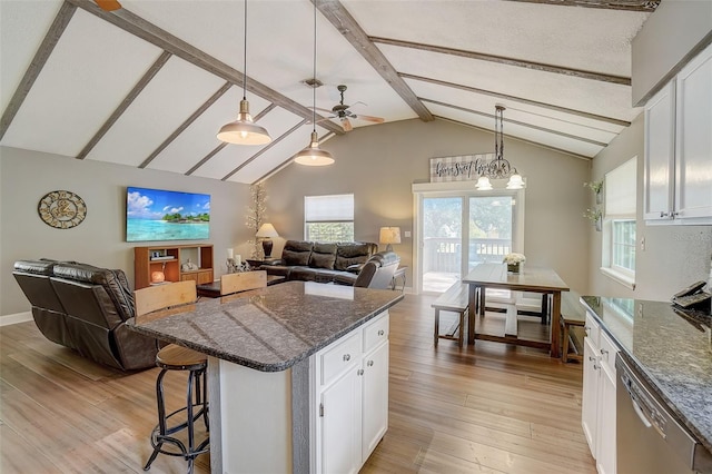 kitchen featuring beamed ceiling, light wood-type flooring, a kitchen island, hanging light fixtures, and white cabinets