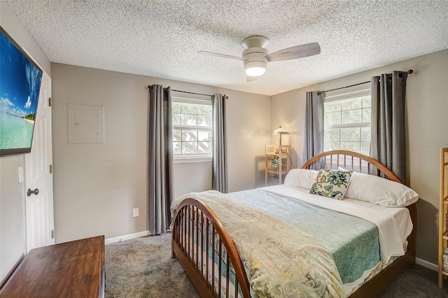 carpeted bedroom featuring ceiling fan and a textured ceiling