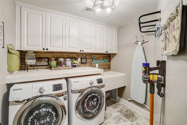 laundry area featuring washer and clothes dryer, cabinets, and light tile floors