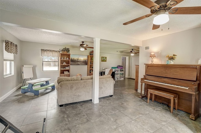 tiled living room featuring ceiling fan and a textured ceiling