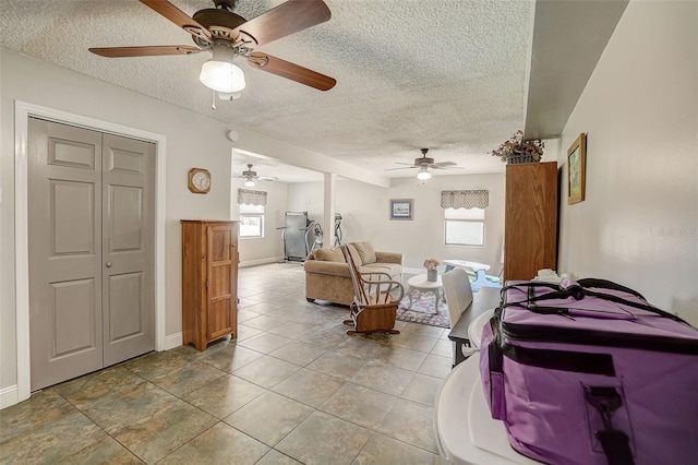 tiled living room featuring a textured ceiling and ceiling fan