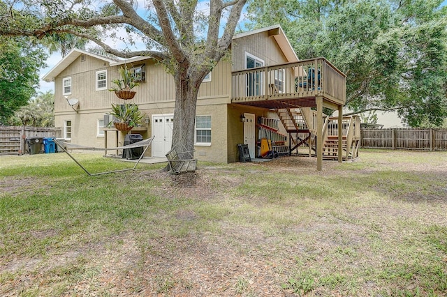 back of house featuring a wooden deck and a lawn