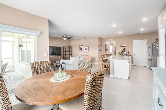 dining room with sink, ceiling fan, and light tile floors