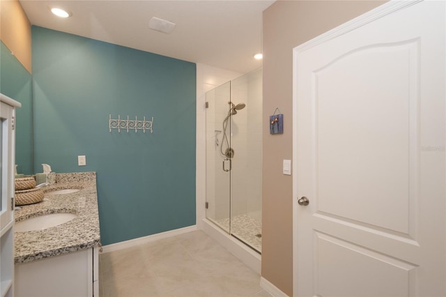 bathroom with a shower with door, double vanity, and tile flooring