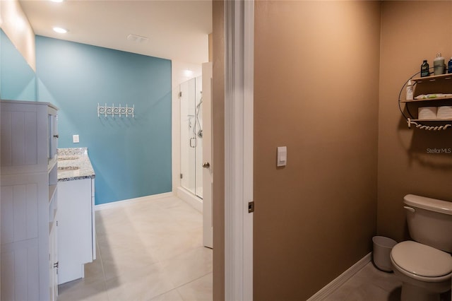 bathroom with tile flooring, vanity, toilet, and a shower with door