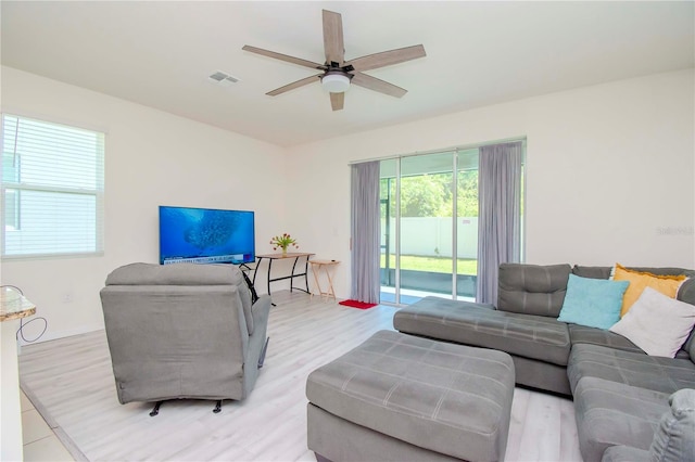 living room with light hardwood / wood-style floors and ceiling fan